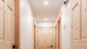 A hallway with wooden doors and a light-colored floor. - The Alpine Cabin Rental (British Columbia)