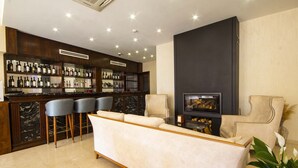 A modern living room with a bar area, a sofa, and two armchairs. - Sota Metekhi Hotel (Tbilisi)