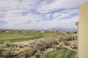 A residential area with a golf course, a fenced pathway, and a building with a patio. - New 5BR Sleeps 18 - Snow Canyon Views & Hot Tub (St. George)
