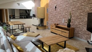 A modern living room with a stone wall, a fireplace, and a sofa with cushions.
