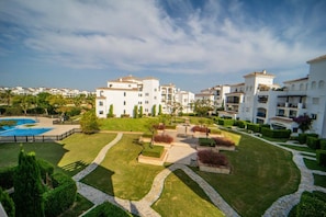 A residential area with multiple white buildings, a swimming pool, and well-maintained gardens. - Two bedroom  in Spain, La Torre Golf Resort (Torre-Pacheco)