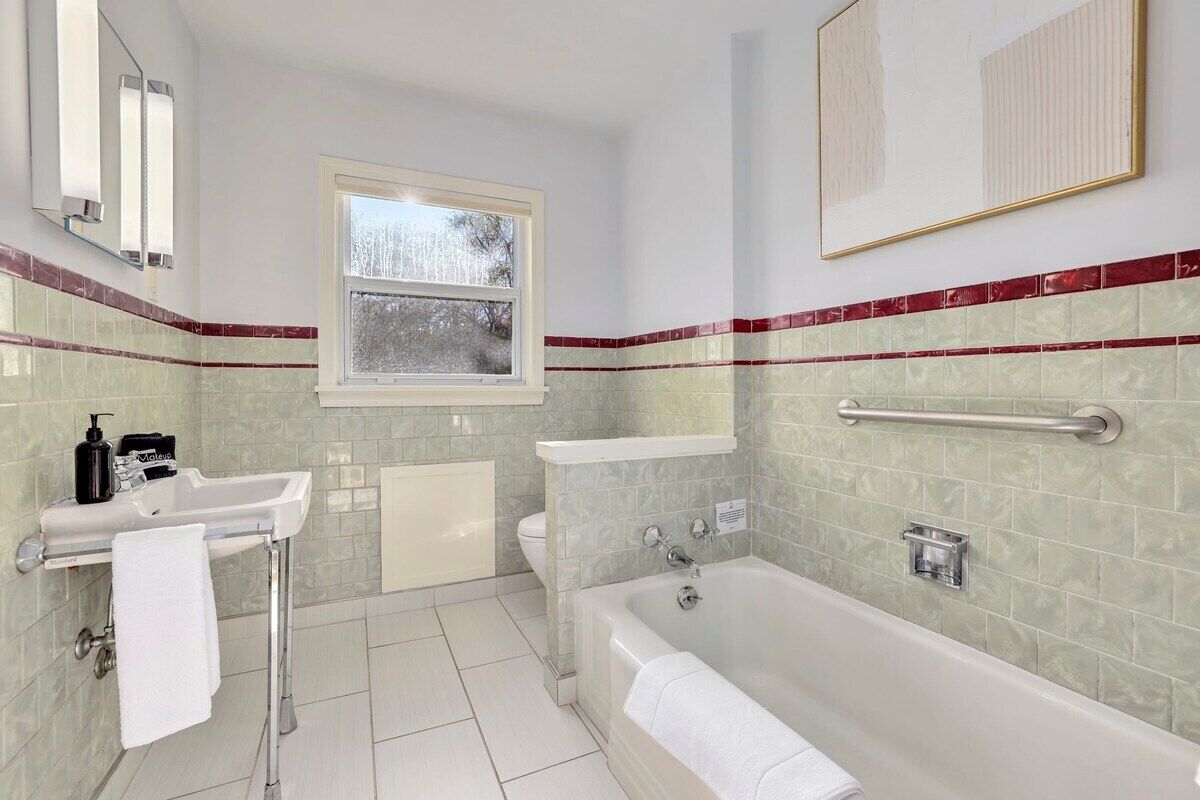 A modern bathroom with a bathtub, a sink, and a toilet.