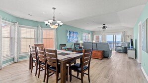 A spacious living area with a dining table, chairs, a sofa, and a ceiling fan. - Updated 3 BR Oceanfront Condo - Drayton House 402 (Myrtle Beach)