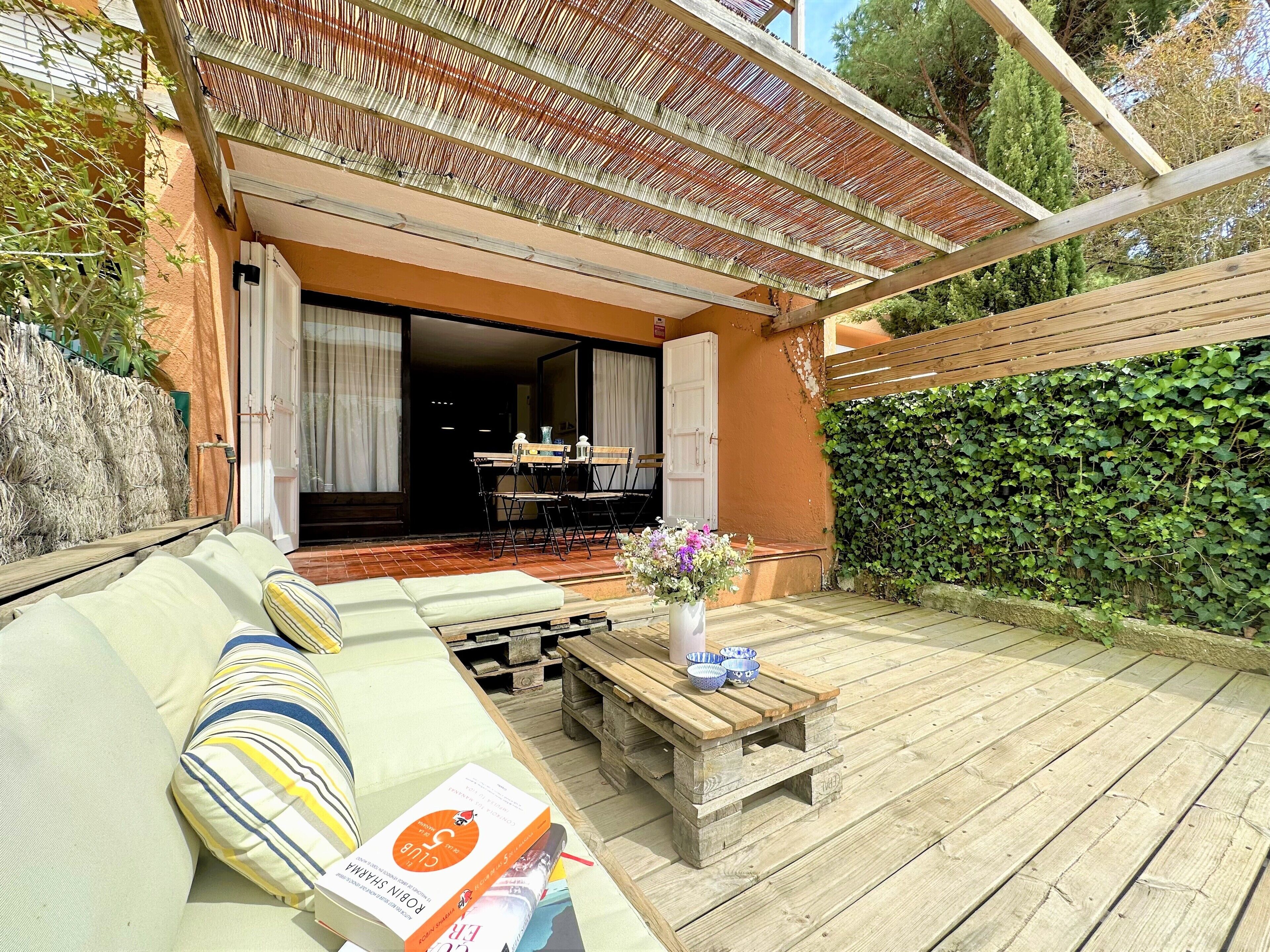 An outdoor seating area with a sofa, a table, and a book.