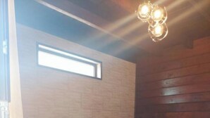 A room with two beds, wooden walls, a ceiling light fixture, and a window. - Come &Rest (Kazbegi)