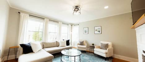 TV connectée, cheminée, livres, écrans d'ordinateur