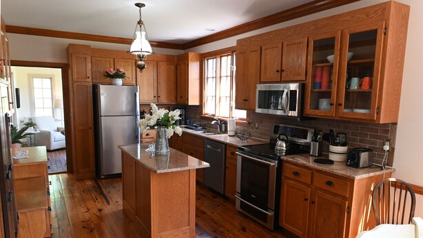 A kitchen with wooden cabinets, stainless steel appliances, and a central island.