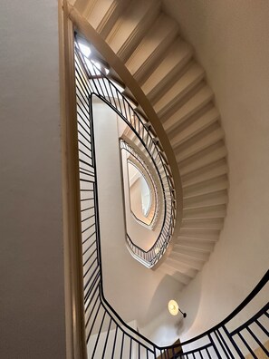 A spiral staircase with a modern design, featuring a central column and a handrail on the outer side. - The Monache Loggia (Gap)