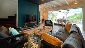 A modern living room with a TV, sofa, and coffee table. - La Villa d'à Côté (Le Marin)