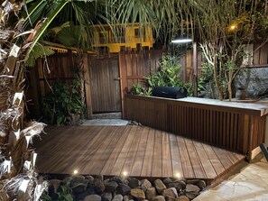 A wooden deck with a built-in barbecue grill, surrounded by tropical plants and a wooden fence. - La Villa d'à Côté (Le Marin)