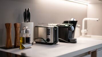 Eine moderne Küche mit Toaster, Kaffeemaschine und einem Messerblock auf der Arbeitsfläche.