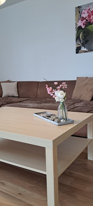 Ein Holztisch mit einer Blumenvase und einer Schale dekorativer Gegenstände.