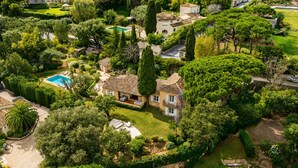A large estate with a swimming pool, multiple buildings, and extensive greenery.