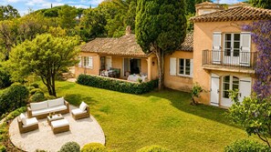 Una villa con patio, mobiliario exterior y un jardín bien cuidado.