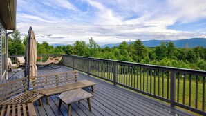 A wooden deck with outdoor furniture, a view of a mountainous landscape, and a clear sky. - Mountain Paradise - Pickleball / Hot Tub / Games (Jewett)