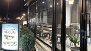 A restaurant with outdoor seating, stone steps, and a signboard. - Bujtina Apsus (Berat)
