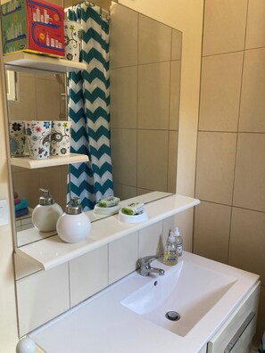 Een haardroger, handdoeken, zeep, toiletpapier