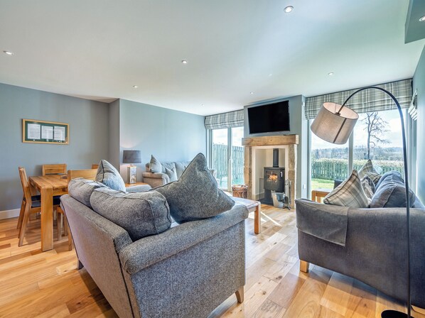 A spacious living area with a fireplace, a dining table, and a sofa.