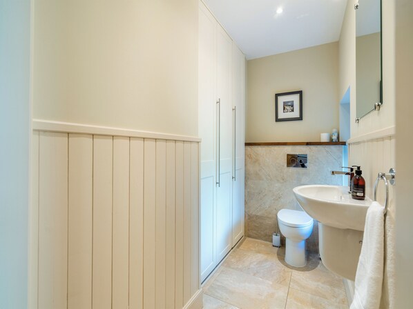 A bathroom with a toilet, sink, and cabinet.