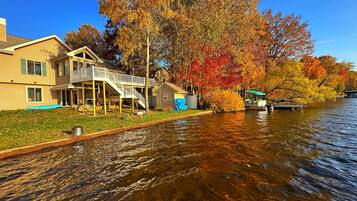 Ein Anwesen am Wasser mit einem Haus, einem Steg und einem Boot.