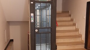 Un escalier surmonté d’une grille métallique, un détecteur d’incendie et une pancarte indiquant qu’il faut utiliser l’escalier en cas d’incendie.