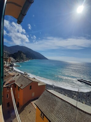 Une vue sur la côte, avec des bâtiments le long de la plage, un ciel dégagé et une montagne en arrière-plan.