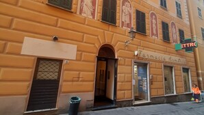 Un immeuble dont le rez-de-chaussée abrite une pharmacie nommée « Farmacia Armonica ».