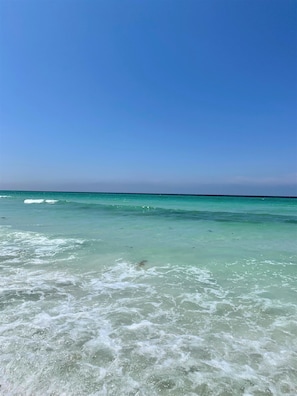 A beach with clear turquoise water and gentle waves.