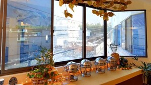 A room with large windows, a long counter with decorative items, and a view of buildings outside. - The Mandarin Inn (Gilgit)