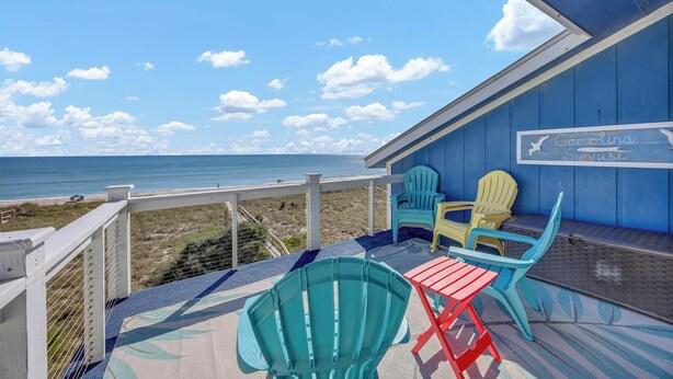 En badebro ved stranden med udsigt over havet, med et skilt, der siger "Carolina Surfside".