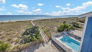 Et poolområde med udsigt til stranden og havet.