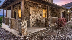 A stone building with a porch, a bench, and a small tree. - Lake View @ Hollows Resort: Pools, Pets, Balconies (Jonestown)
