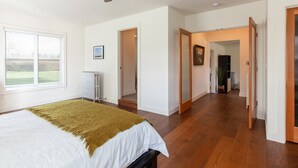 Un dormitorio con una cama, un radiador, un ventilador de techo y una ventana con persianas.