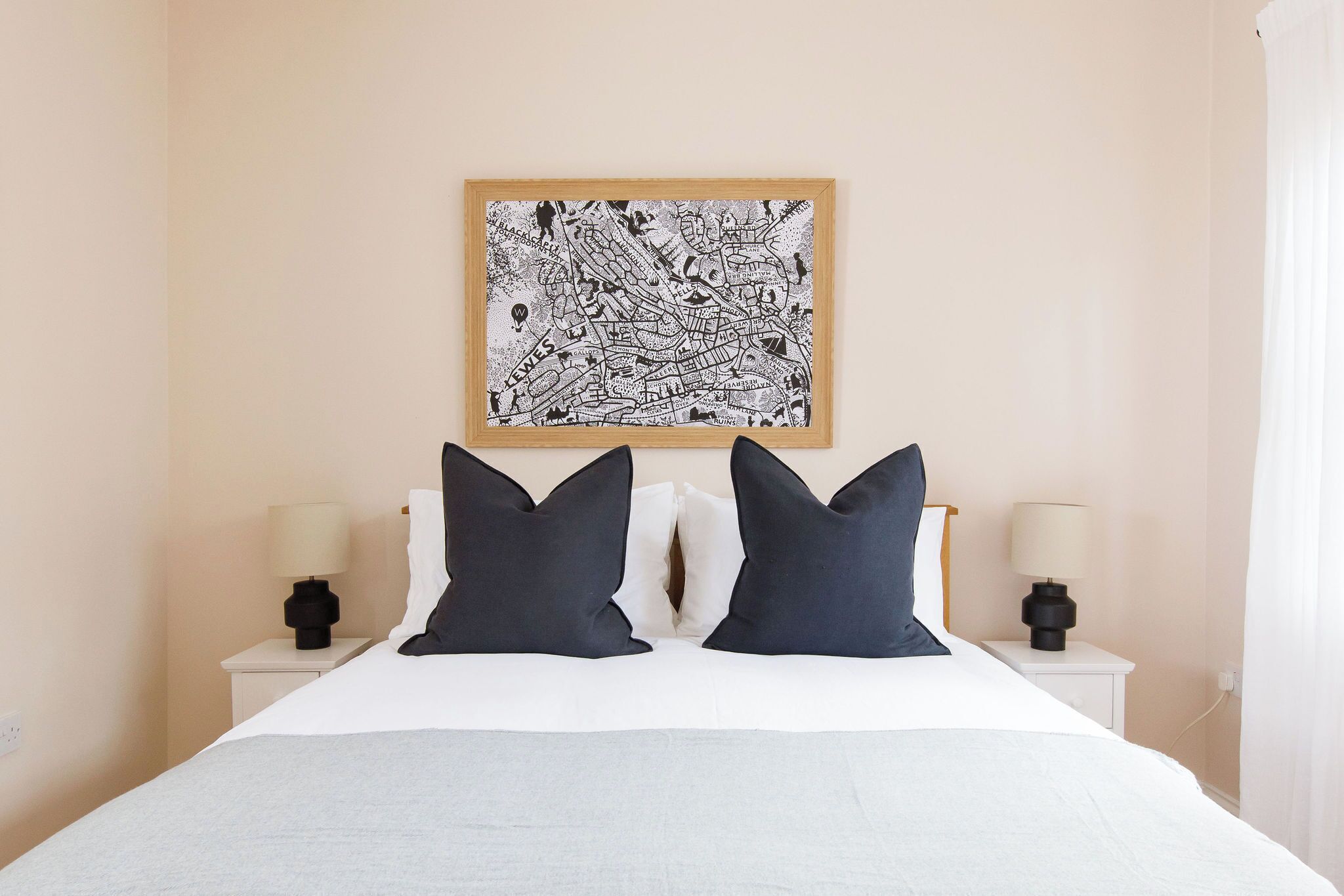 Downstairs bedroom with side tables and wall art 