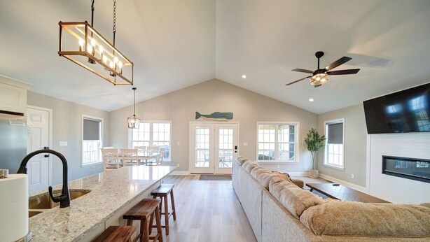 A spacious kitchen with a large island, wooden bar stools, and a ceiling fan.