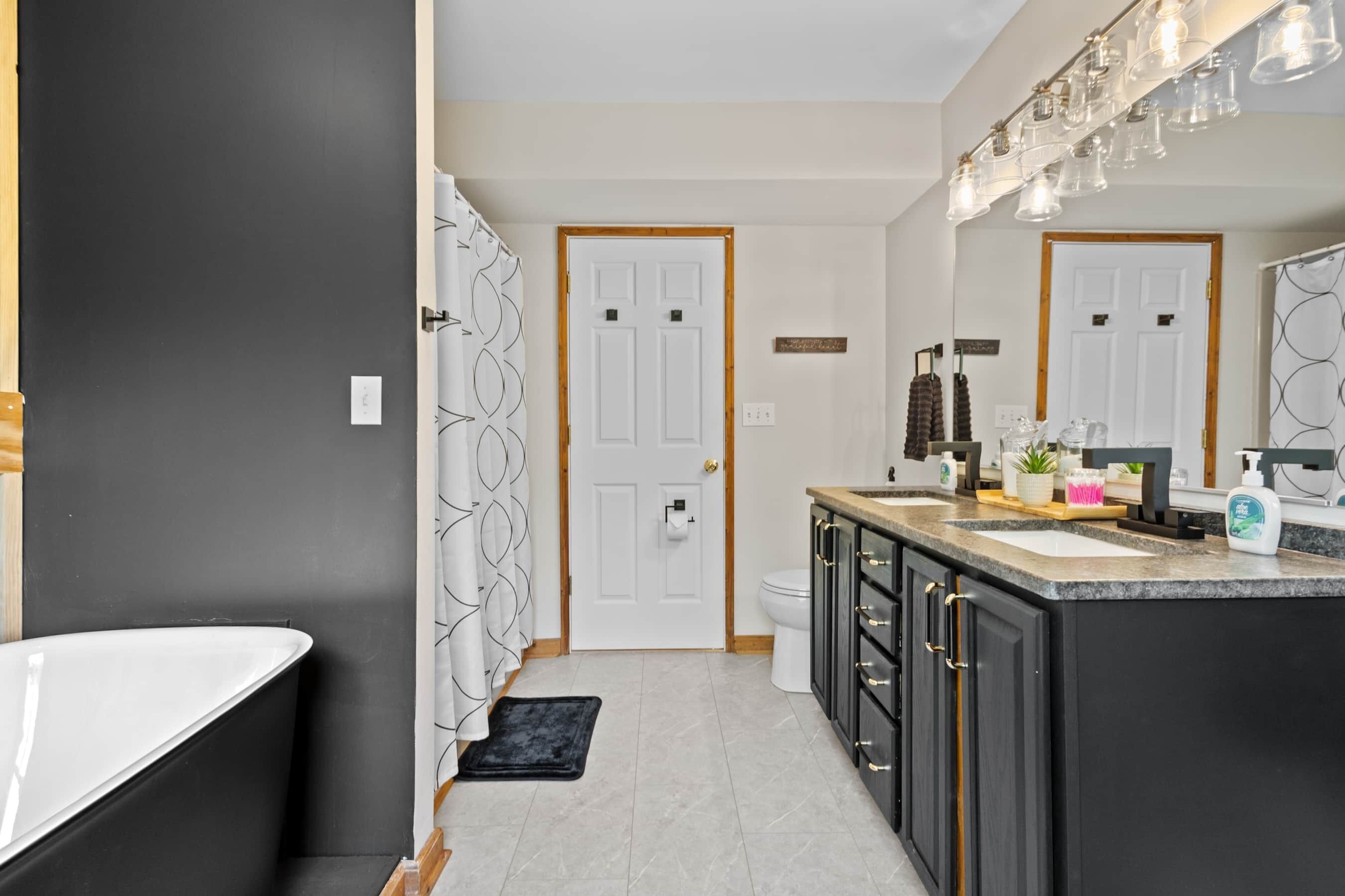 A modern bathroom with a freestanding bathtub, a vanity with a sink, and a mirror.