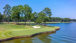 A golf course with a water hazard, trees, and a clear sky. - Pet Friendly in Great Waters, Docks, Tennis, Pool (Eatonton)