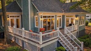 A two-story house with a covered porch, a staircase, and a garage. - Pet Friendly in Great Waters, Docks, Tennis, Pool (Eatonton)