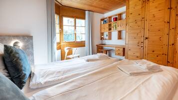 Una camera d'albergo con due letti, una scrivania e un armadio.