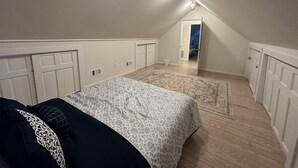 A bedroom with a bed, a patterned rug, a hallway, and a door leading to another room. - POOL, 5 min walk to Jenks, 4 Bedroom, 4 car parking, beach badges, Fence, Pets (Point Pleasant Beach)