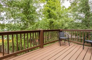 Relax on the deck surrounded by lush greenery.