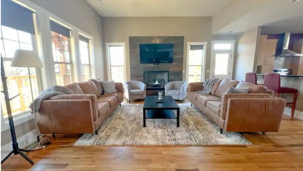 Ein geräumiges Wohnzimmer mit zwei Sofas, einem Couchtisch und einem Kamin.