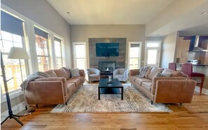Relax in this stylish living room with two comfortable sofas, a central coffee table, and a flat-screen TV.