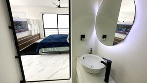 Un dormitorio moderno con una cama grande, un ventilador de techo y un televisor que muestra un noticiero.