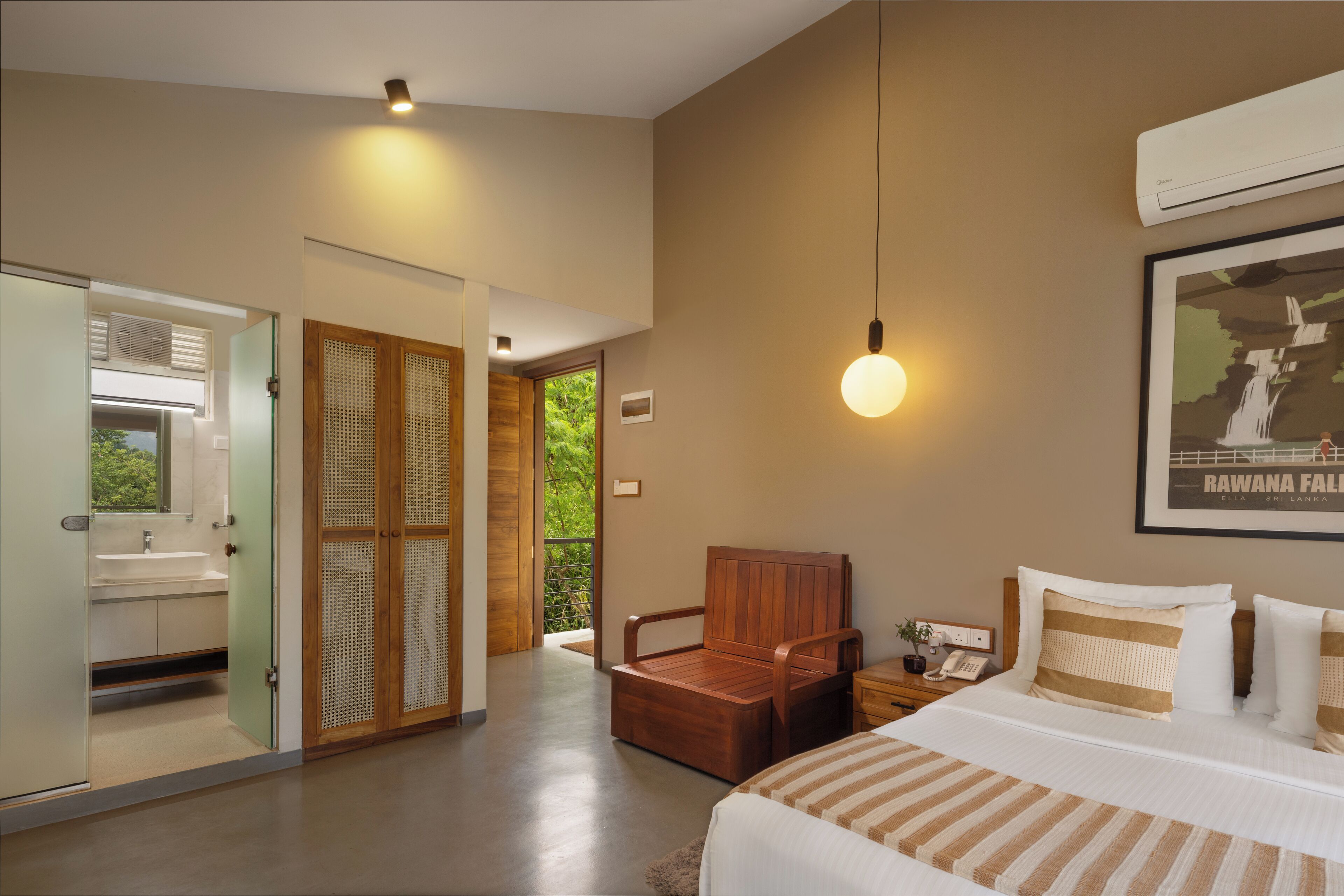 A modern hotel room with a bed, bedside table, and a view of the outdoors.
