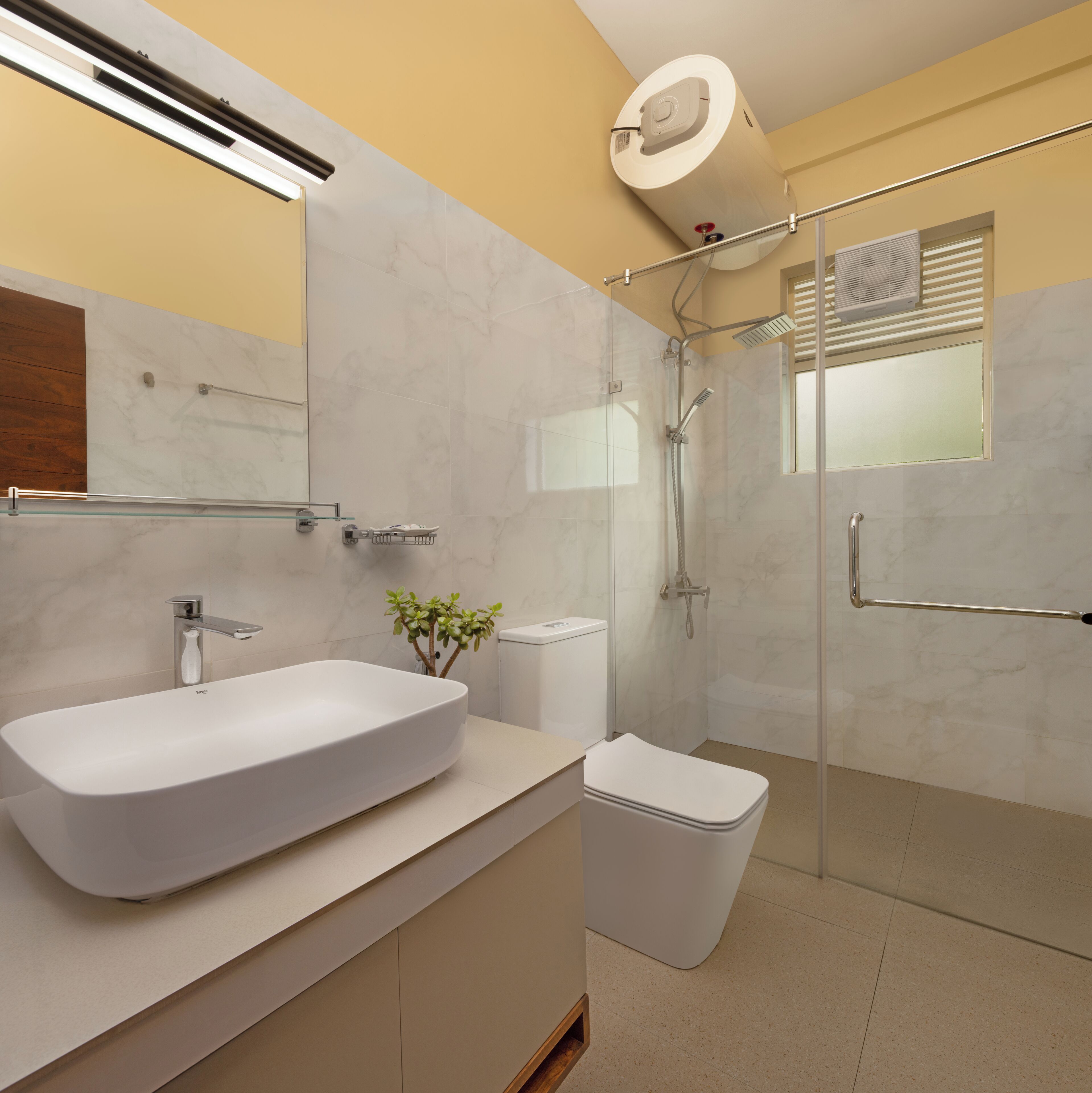 A modern bathroom with a large white sink, a glass shower enclosure, and a toilet.