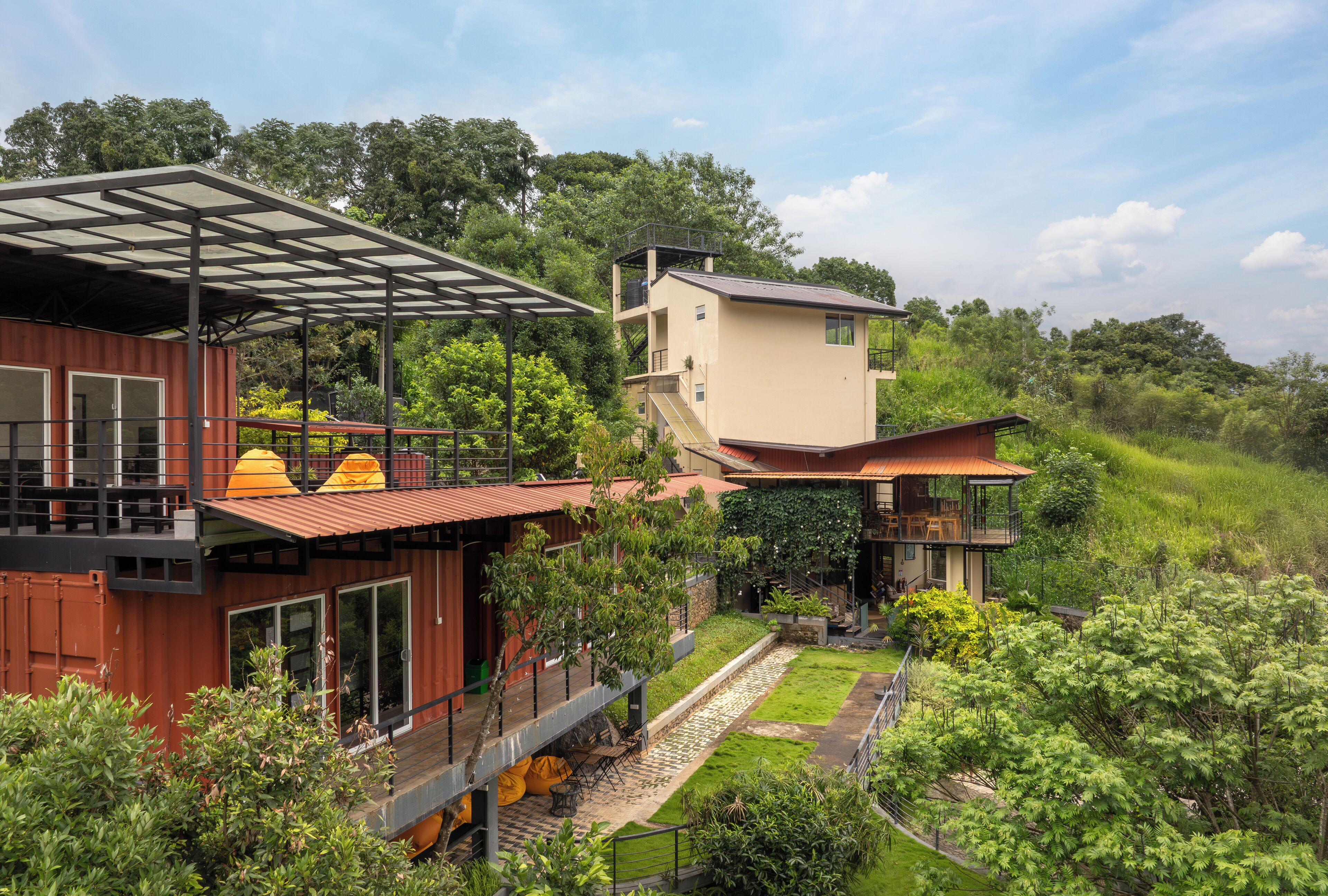 A modern house with a wooden deck, a covered outdoor area, and a small garden.