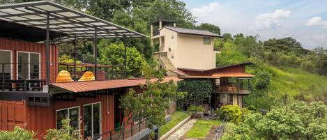 A modern house with a wooden deck, a covered outdoor area, and a small garden.