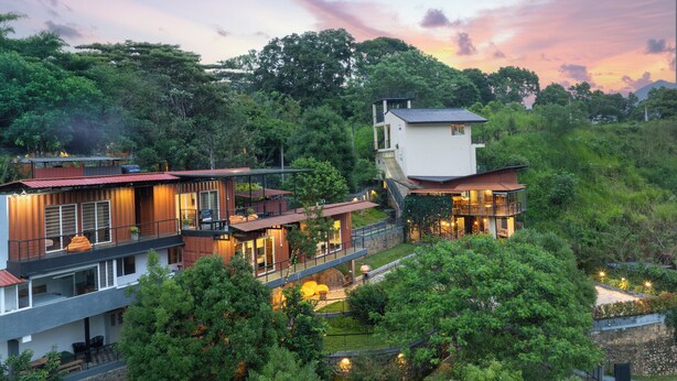 A modern multi-story house with a balcony, surrounded by lush greenery and a scenic sunset view. - The Cubes Ella  (Ella)