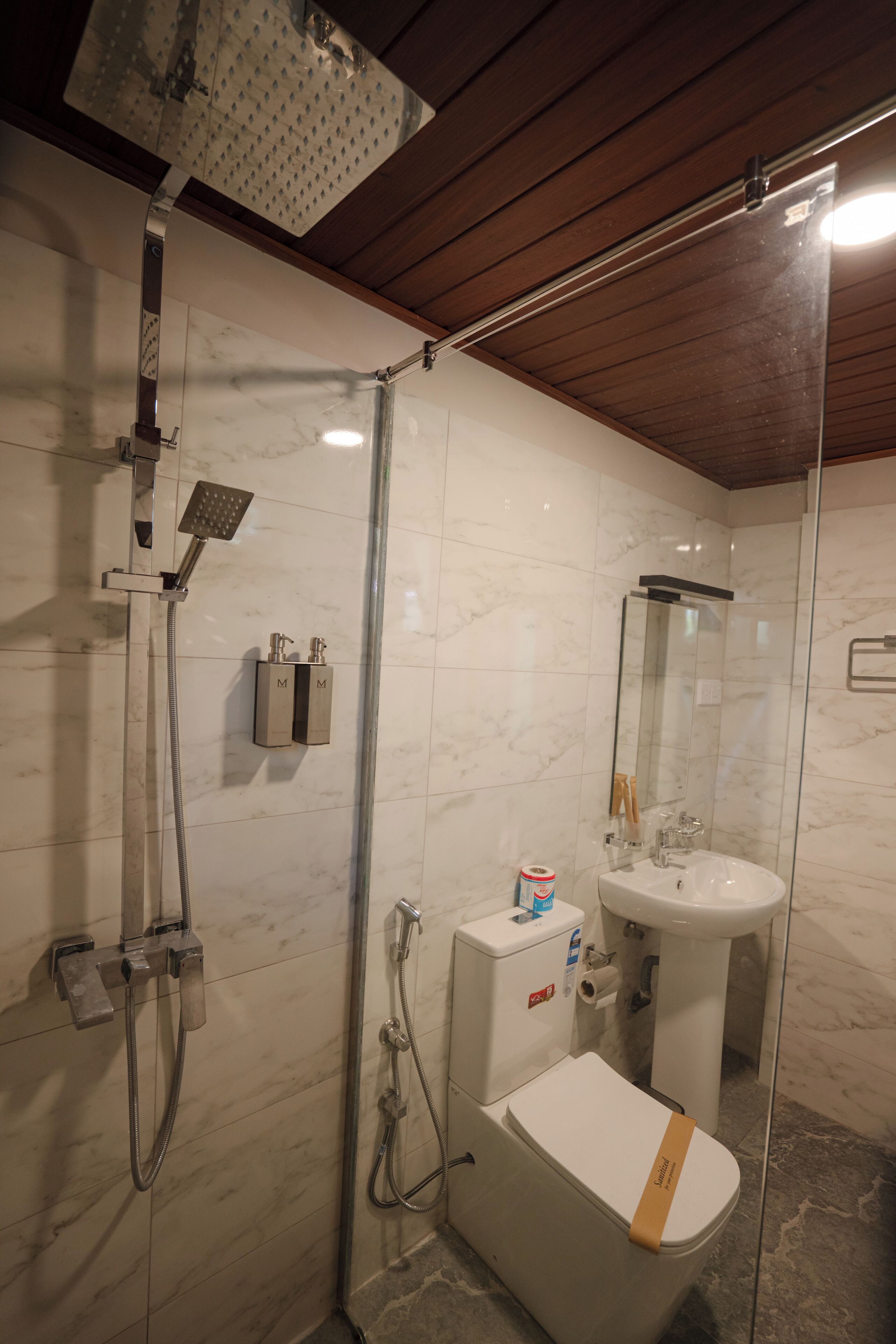 A bathroom with a shower, toilet, and sink, all with modern fixtures.